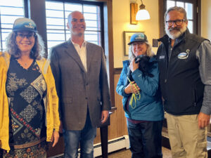 Kathy Swartz MSTPF Board, Walter Panzirer Helmsley Trustee, Loraine Cordova MSTPF Board, and Stuart Leidner AK State Parks Superintendent for Mat-Su and Copper Basin Region, warming up at the Manager's House before taking a tour of the other buildings at IMSHP.